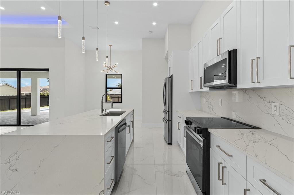 Kitchen featuring appliances with stainless steel finishes, plenty of natural light, recessed lighting, and a sink