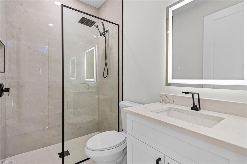 Full bathroom with vanity, toilet, and a stall shower