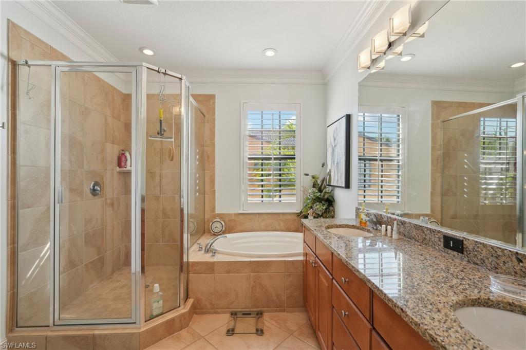 Bathroom with tile patterned flooring, a sink, a bath, and a shower stall