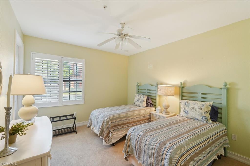 Carpeted bedroom featuring a ceiling fan and baseboards