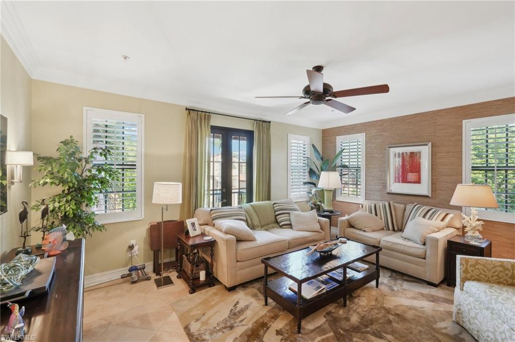 Living room featuring a healthy amount of sunlight, baseboards, a ceiling fan, and french doors