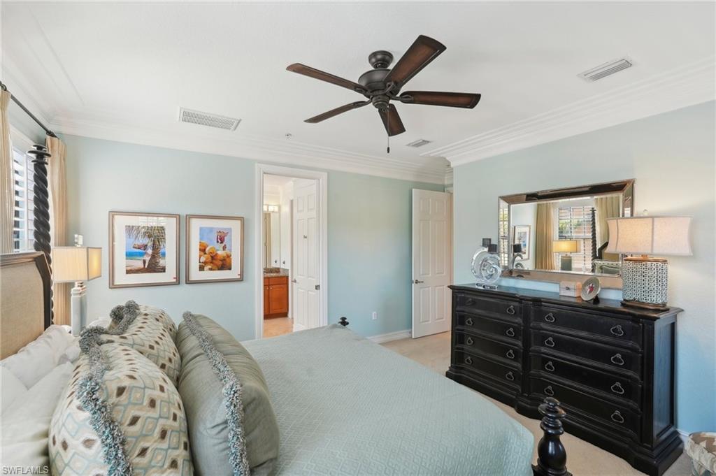 Bedroom featuring visible vents, crown molding, and light carpet