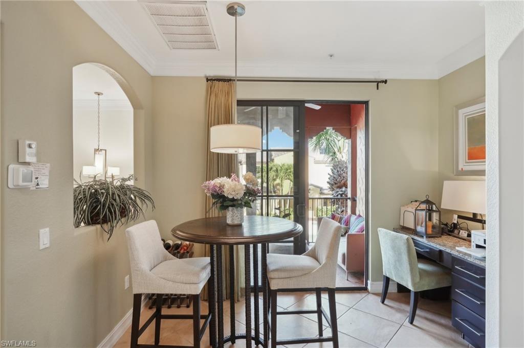 Dining room featuring crown molding, light tile patterned flooring, arched walkways, and visible vents