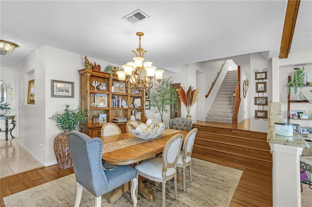 Casual Dining space featuring engineered wood durable flooring, stairs, open to the family room and kitchen
