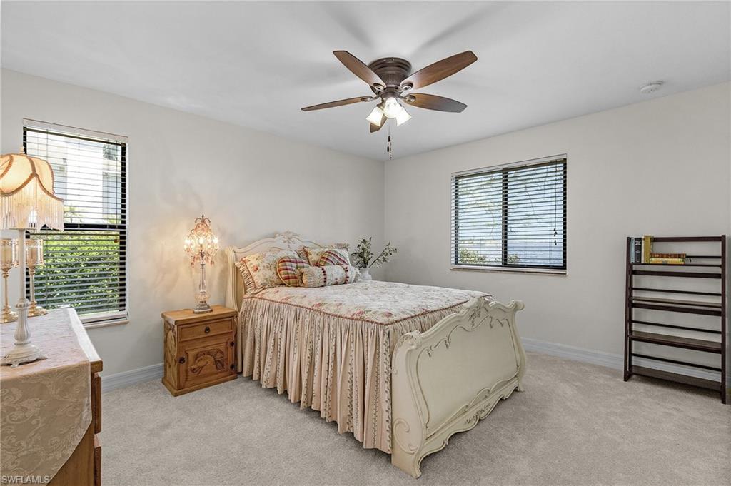 Bedroom #4 with baseboards, a ceiling fan, light carpet, and multiple windows with River view and walk in closet
