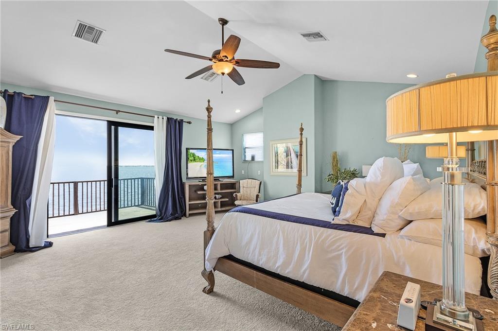 Primary upstairs ensuite bedroom ,  featuring new carpet , cathedral ceiling, ceiling fan, access to deck, and huge walk in closet