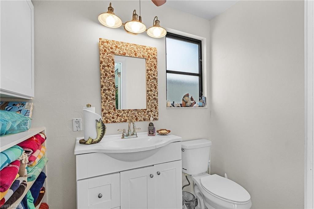 Pool bath with vanity and toilet and beach towel and toy storage