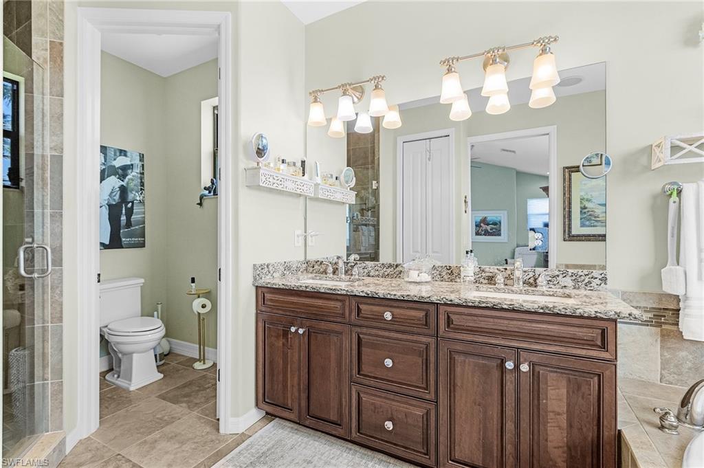 Ensuite bathroom with double vanity, a sink, ensuite bathroom, and a stall shower