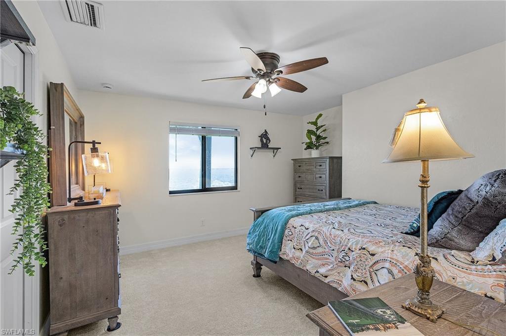 Bedroom # 3 featuring baseboards, light colored carpet, ceiling fan, River view and walk in closet