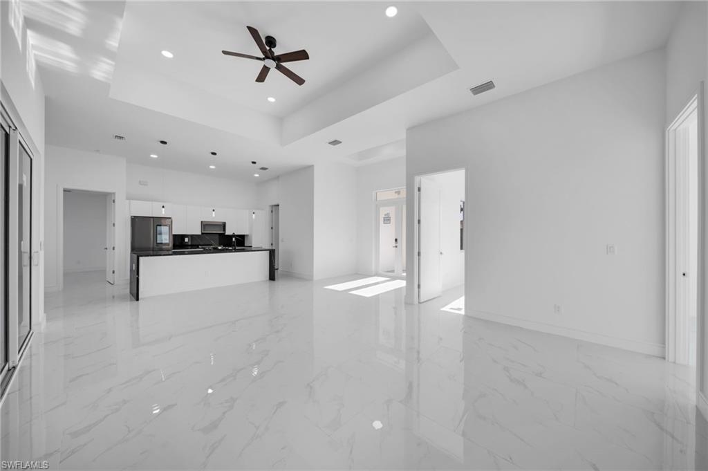 Kitchen featuring freestanding refrigerator, modern cabinets, black dishwasher, a sink, and stainless steel range with electric cooktop