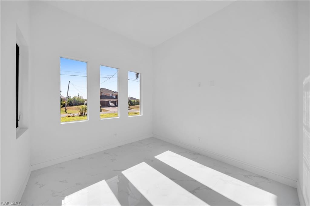 Empty room featuring baseboards and marble finish floor