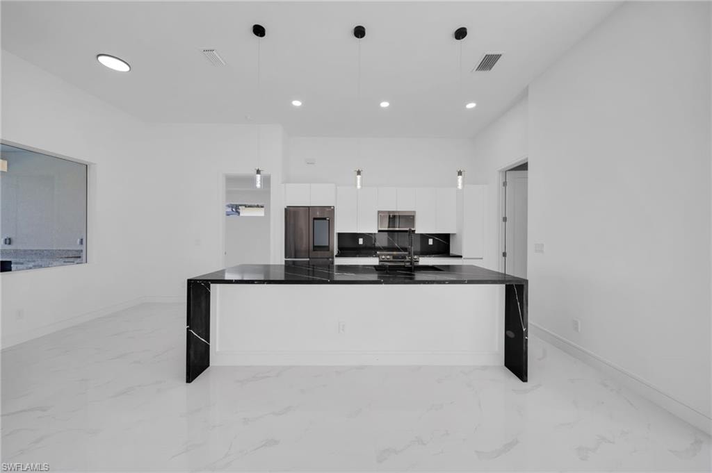 Unfurnished living room featuring a ceiling fan, recessed lighting, and visible vents