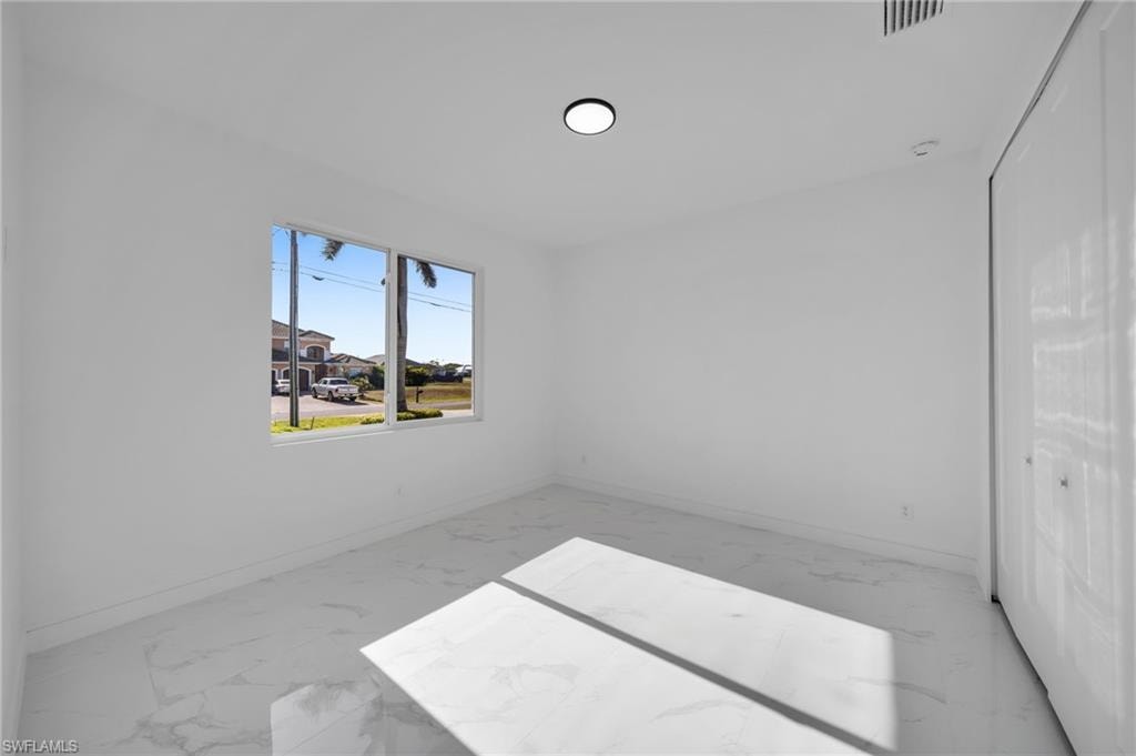 Unfurnished bedroom featuring visible vents, marble finish floor, baseboards, and a closet
