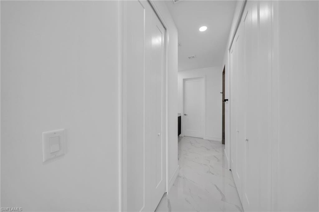 Full bath featuring double vanity, toilet, a sink, and marble finish floor