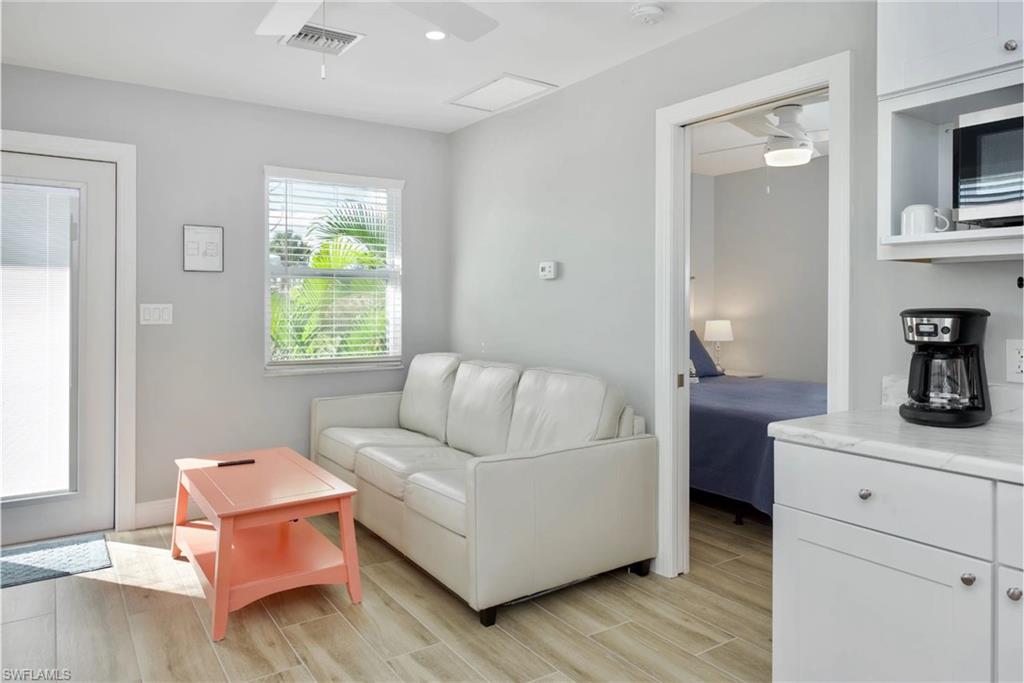 Spacious living area with ample natural light, perfect for entertaining or relaxing (Beach home 2) - Virtually Edited Image