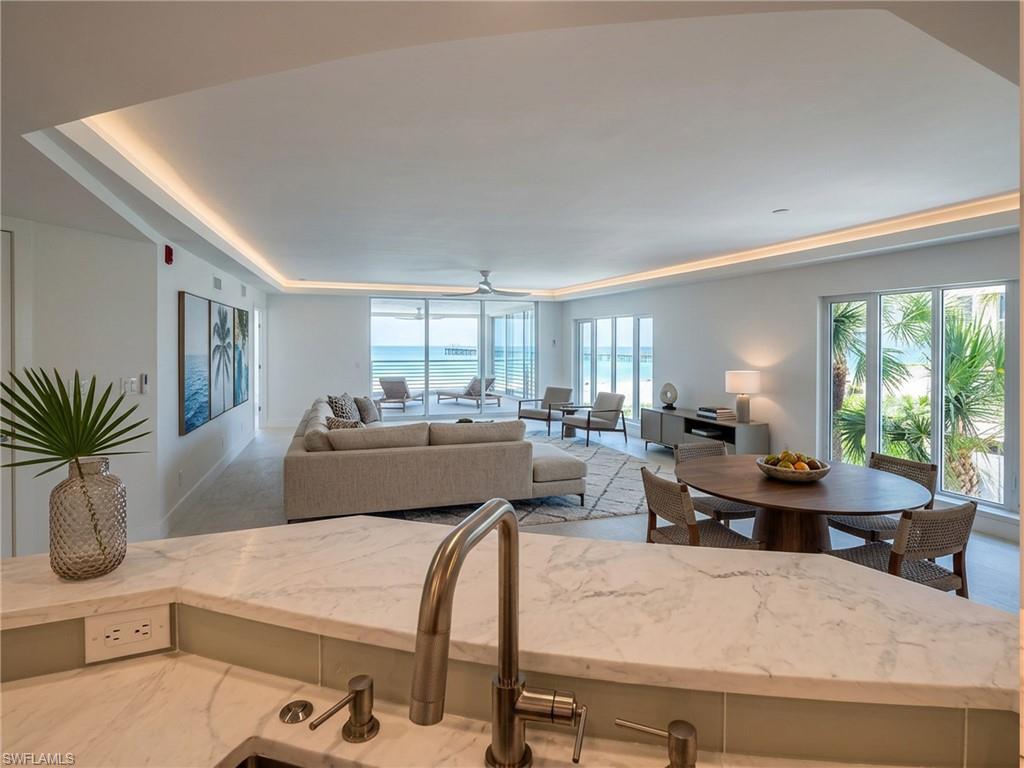 View of living dining areas from the kitchen - virtually staged