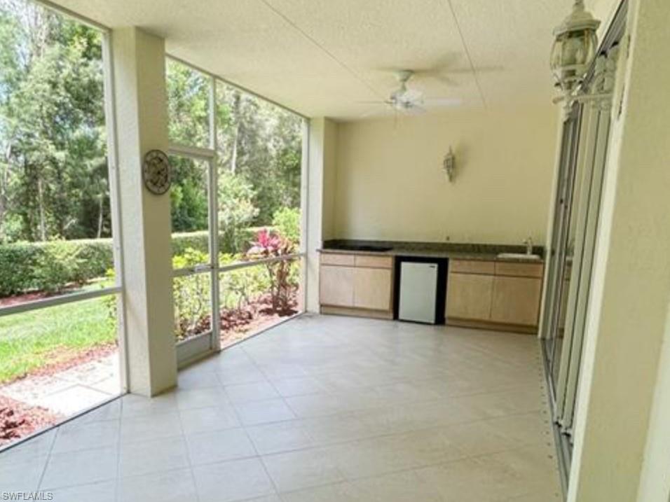 Unfurnished sunroom with a sink, ceiling fan, and plenty of natural light