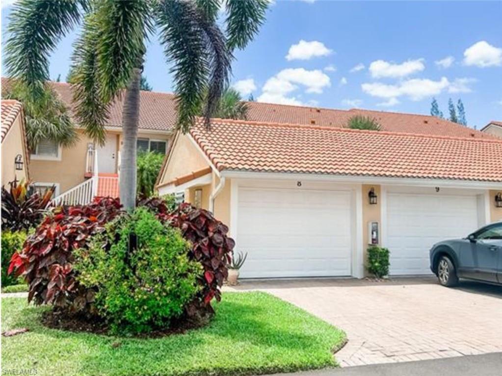 View of front of home featuring an attached garage, stucco siding, and a tile roof