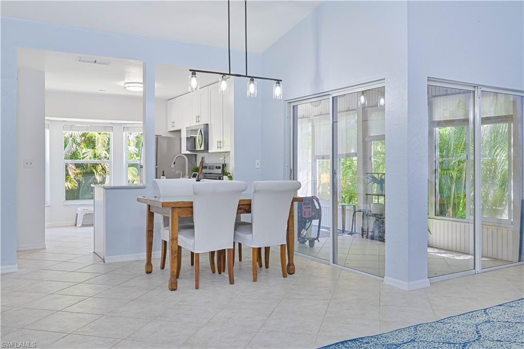 Dining area with light tile patterned flooring, baseboards, and visible vents