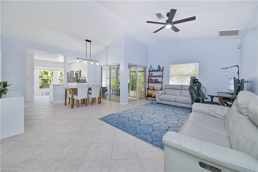 Living room with light tile patterned floors, ceiling fan, and visible vents