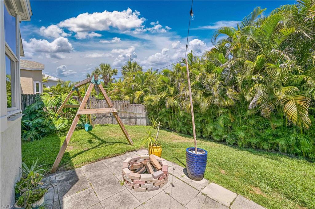 View of patio / terrace featuring a playground, fence, and an outdoor fire pit