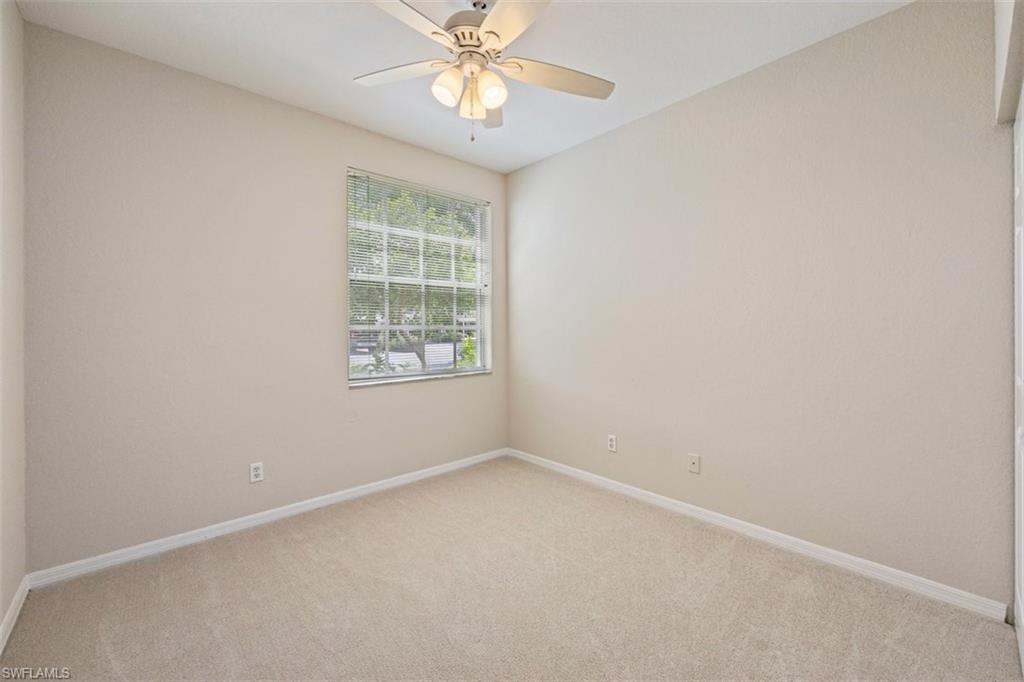 Empty room featuring light carpet and a ceiling fan