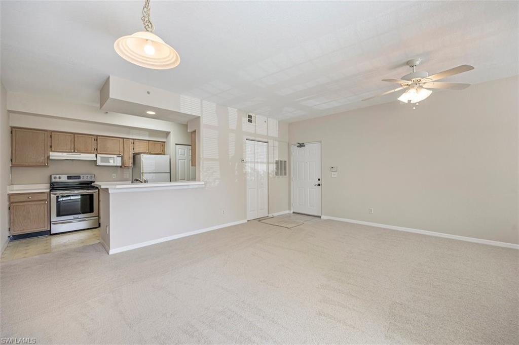 Unfurnished living room with light colored carpet and a ceiling fan