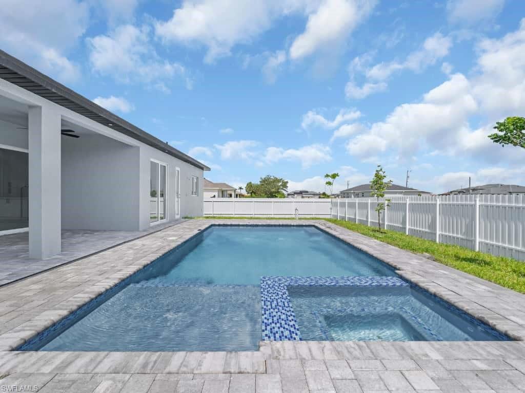 Rear view of house with a ceiling fan, a fenced backyard, stucco siding, and a patio area