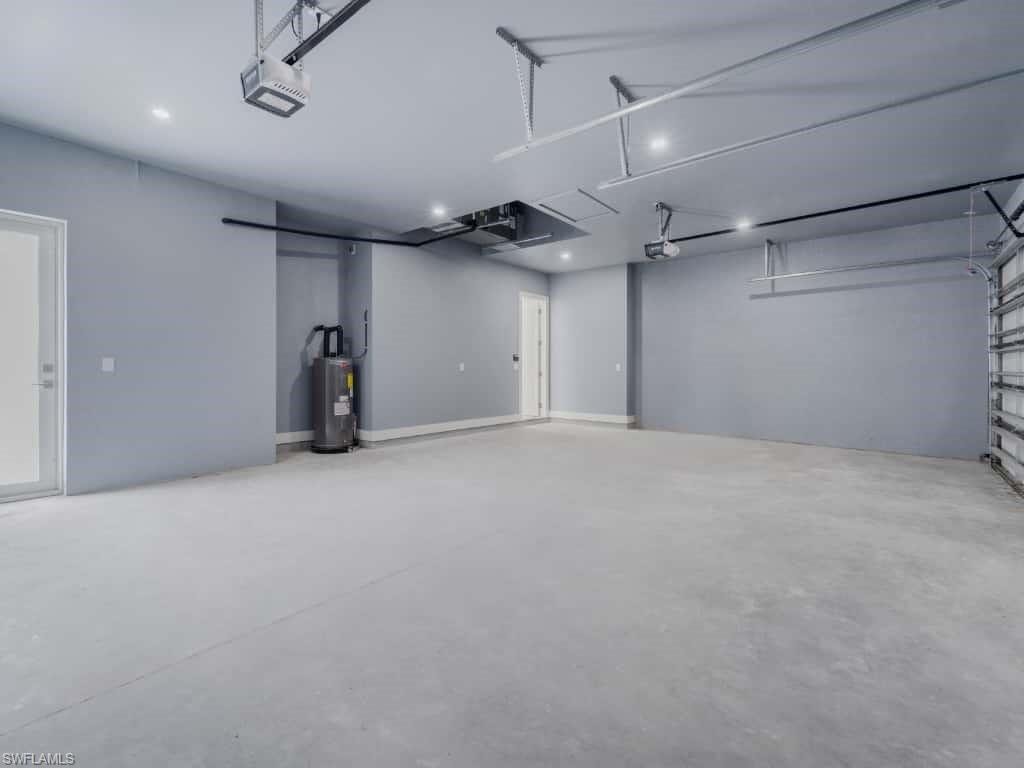 Garage with electric water heater, a garage door opener, and recessed lighting