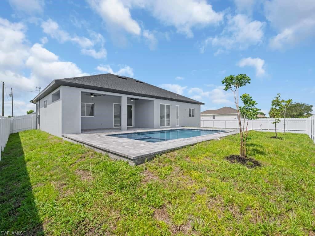 Rear view of property with a patio area, stucco siding, a jacuzzi, and a residential view