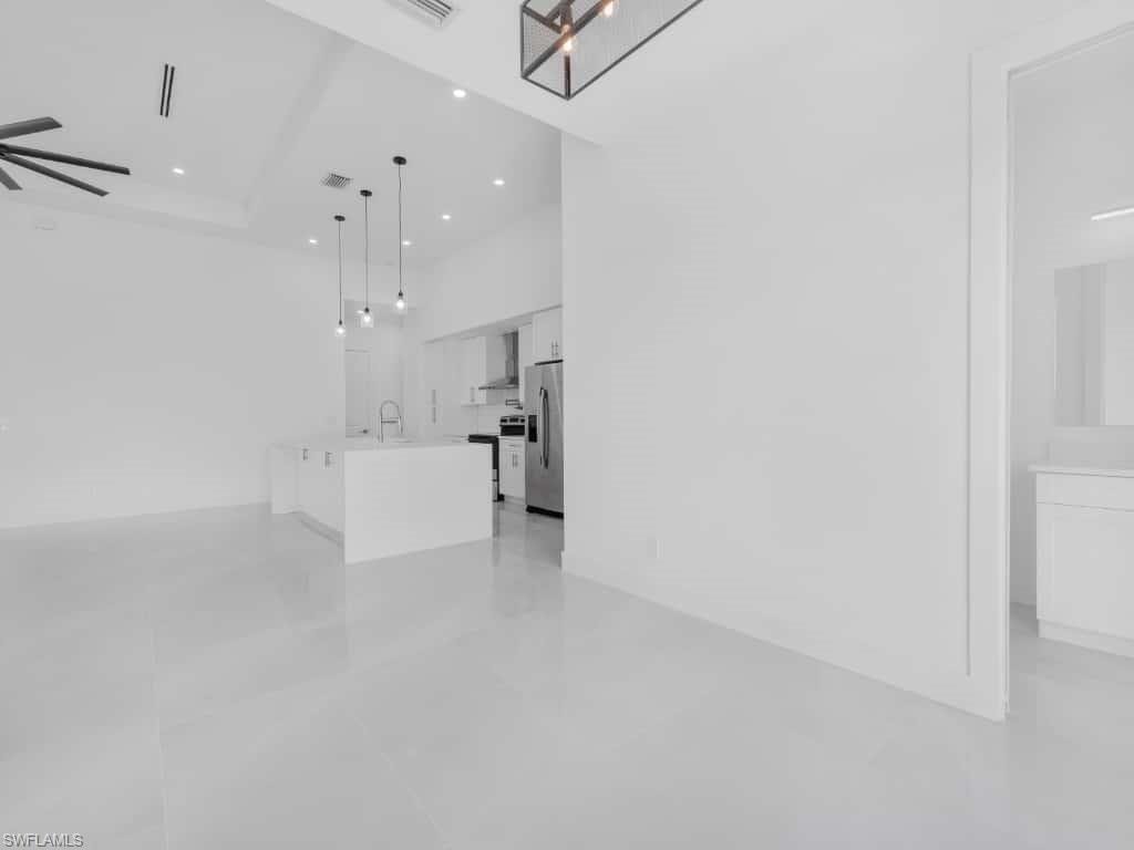 Unfurnished room with a ceiling fan, a raised ceiling, and recessed lighting
