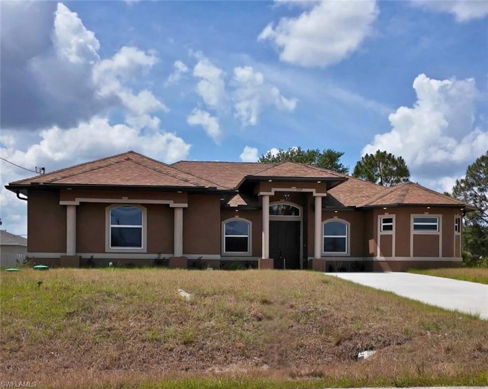 View of front of house featuring a front yard, stucco siding, and a shingled roof