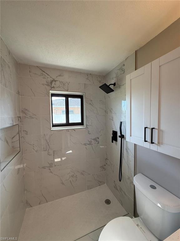 Bathroom with toilet and tiled shower