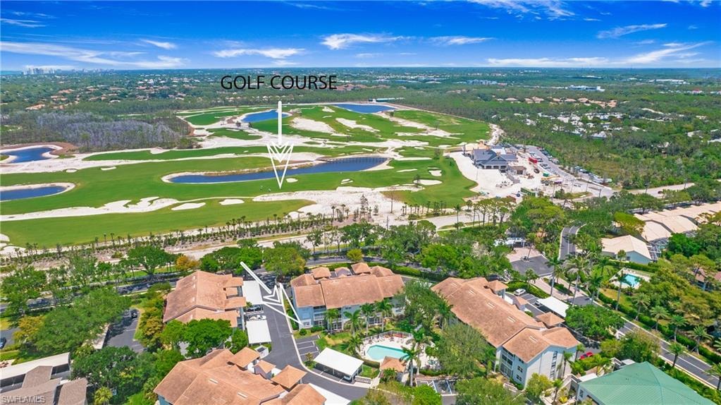 View of property location featuring a large body of water, a golf course, and nearby suburban area