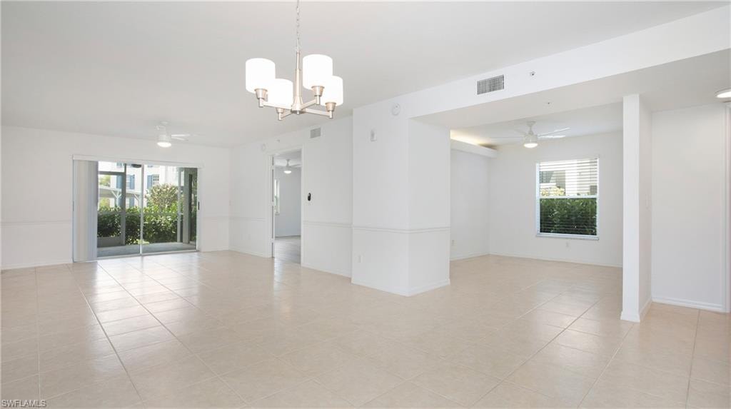 Family room with a chandelier, light tile patterned flooring, a ceiling fan, and baseboards