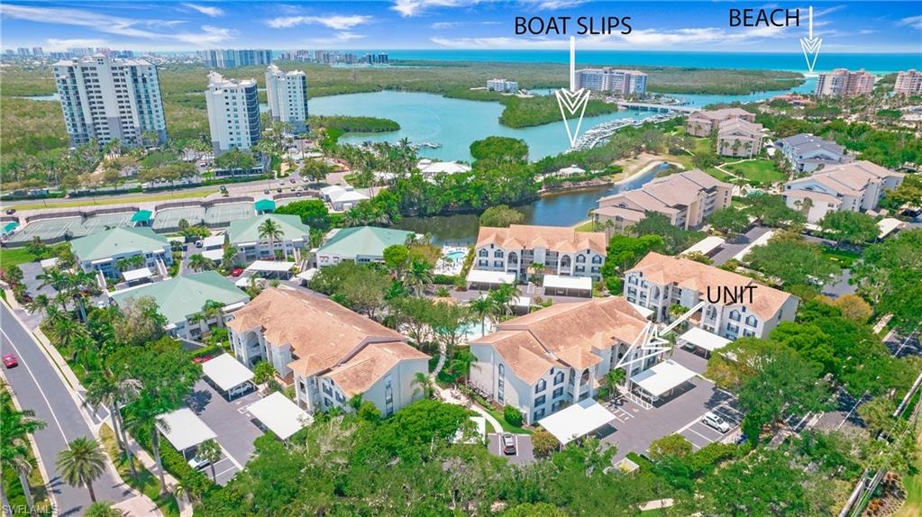 Aerial view of property and surrounding area with a nearby body of water and nearby urban area