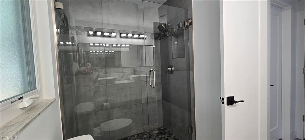 Full bathroom featuring a shower stall