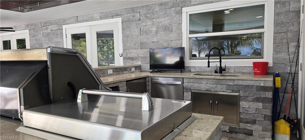 Bar area with a sink and stainless steel dishwasher