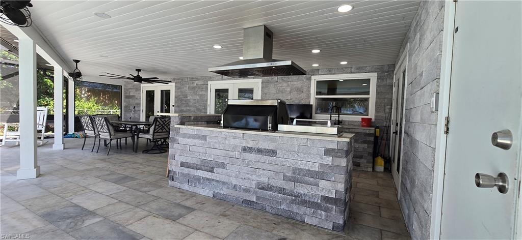 View of patio with area for grilling, outdoor dining area, ceiling fan, and french doors