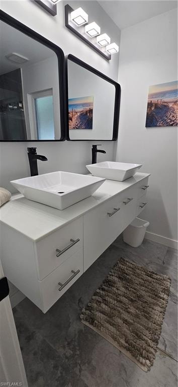 Full bath featuring double vanity and baseboards