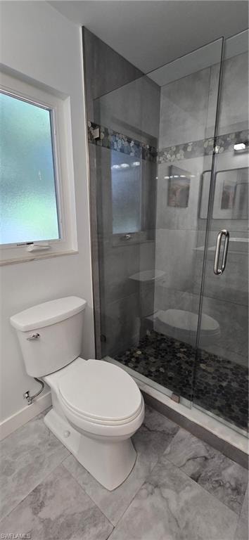 Full bathroom with toilet, a stall shower, and baseboards