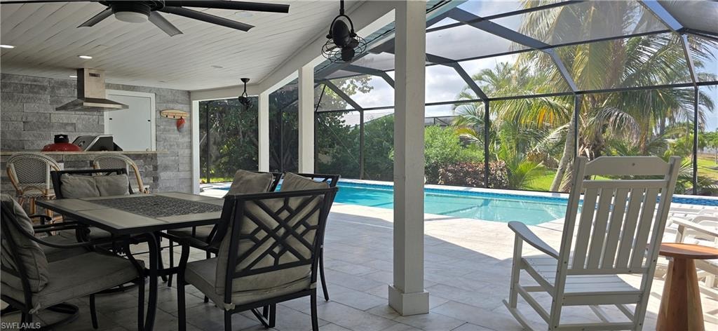 Swimming pool with ceiling fan, a patio area, outdoor dining area, area for grilling, and glass enclosure