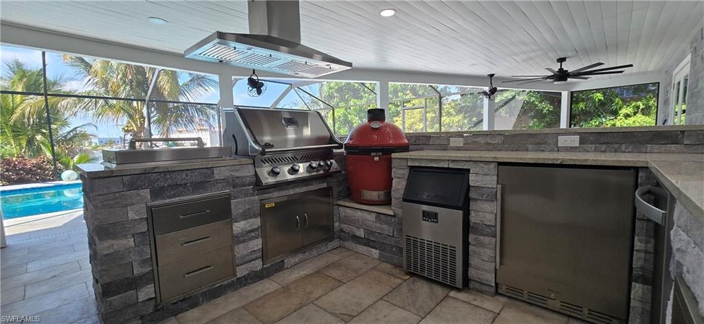 View of patio with exterior kitchen, grilling area, a lanai, and an outdoor pool