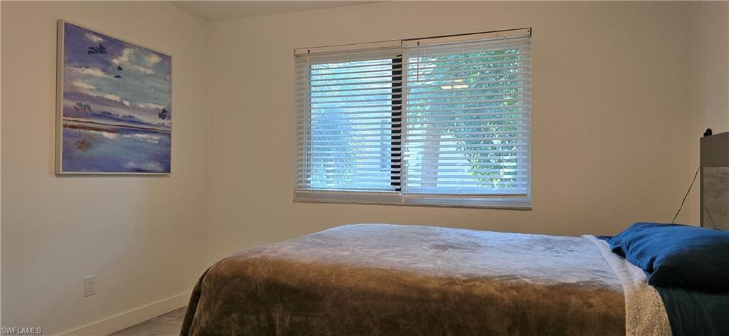Bedroom featuring multiple windows and baseboards