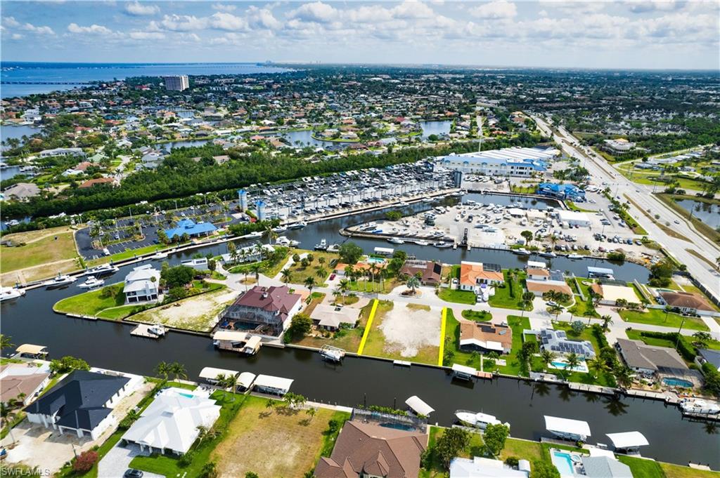 View of property location featuring a large body of water, property parcel outlined, and nearby suburban area