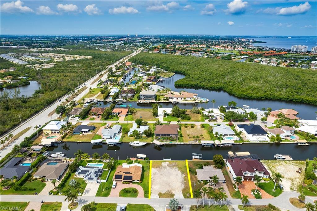 Aerial overview of property's location with property boundaries highlighted, a large body of water, and nearby suburban area