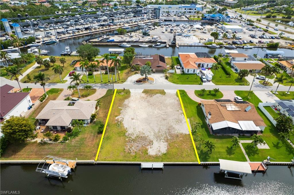 Aerial view of property and surrounding area with a large body of water and property parcel outlined