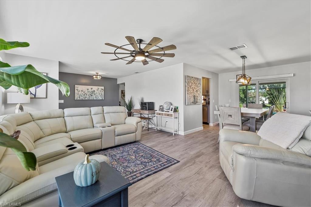 Living room with light wood-style floors, ceiling fan, and baseboards