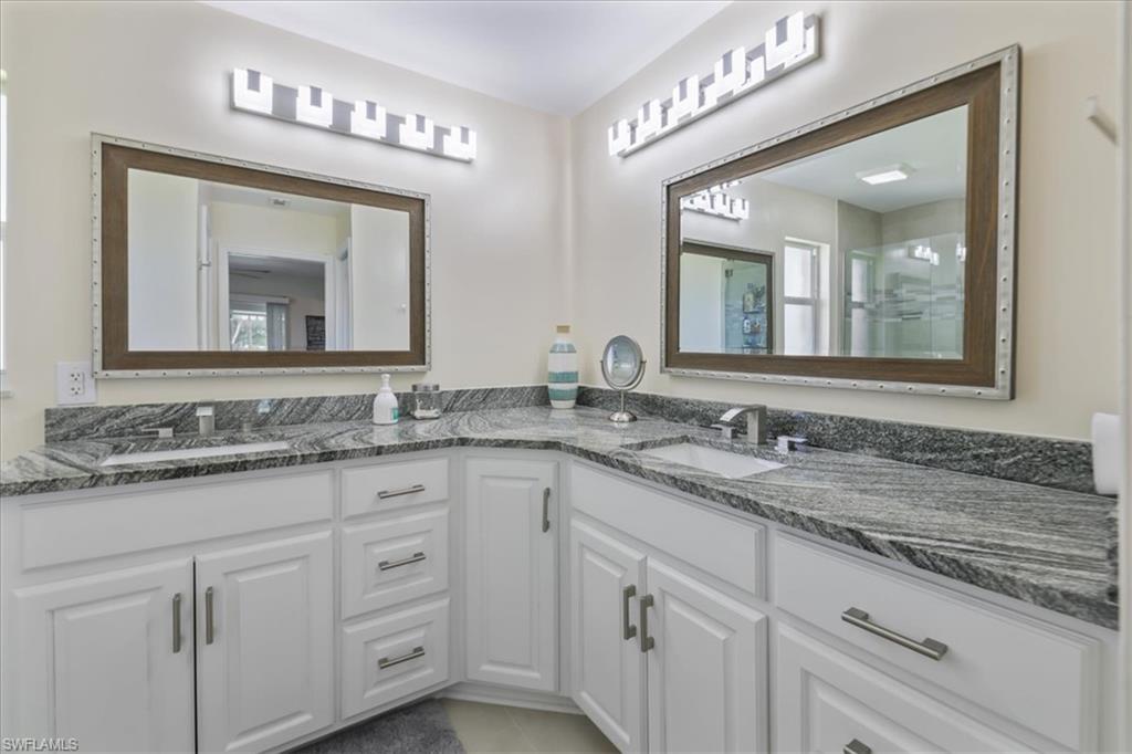 Bathroom featuring double vanity and a shower with shower door