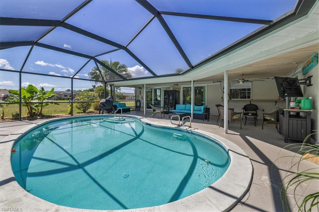 Swimming pool with a patio, an outdoor hangout area, ceiling fan, and a lanai
